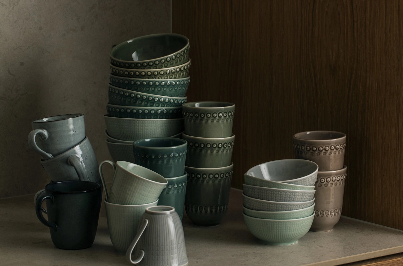 Gröna, grå och bruna koppar som är staplade på varandra