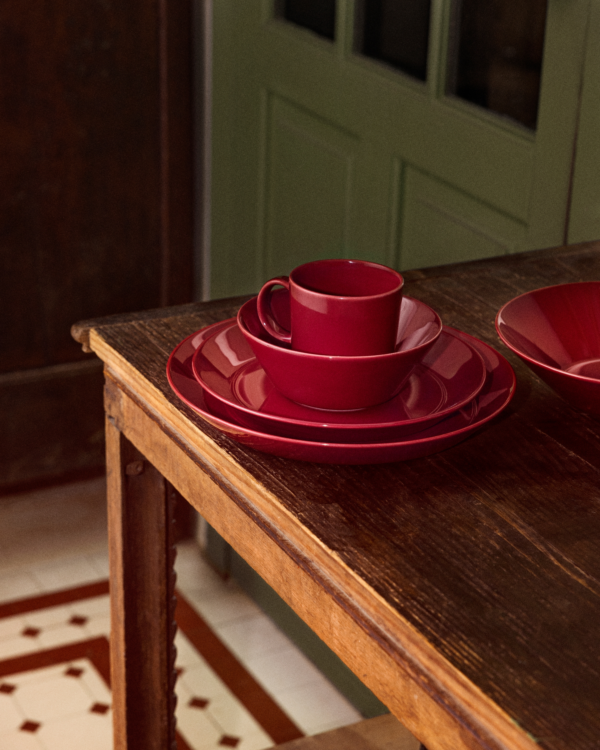 Juhlava joulupöytä punaisilla lautasilla.