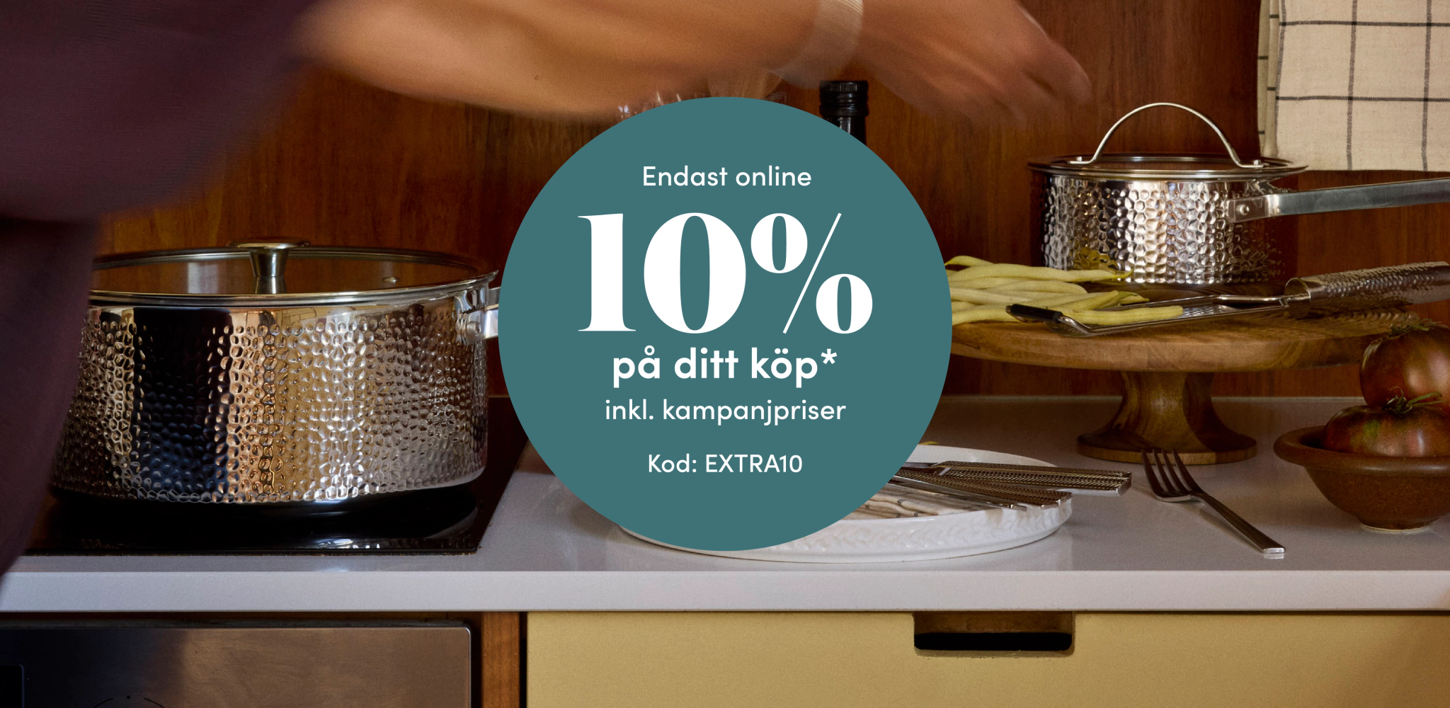 Hamrade kastruller i ett kök med onlineerbjudande om 10 % rabatt på ditt köp med koden EXTRA10.