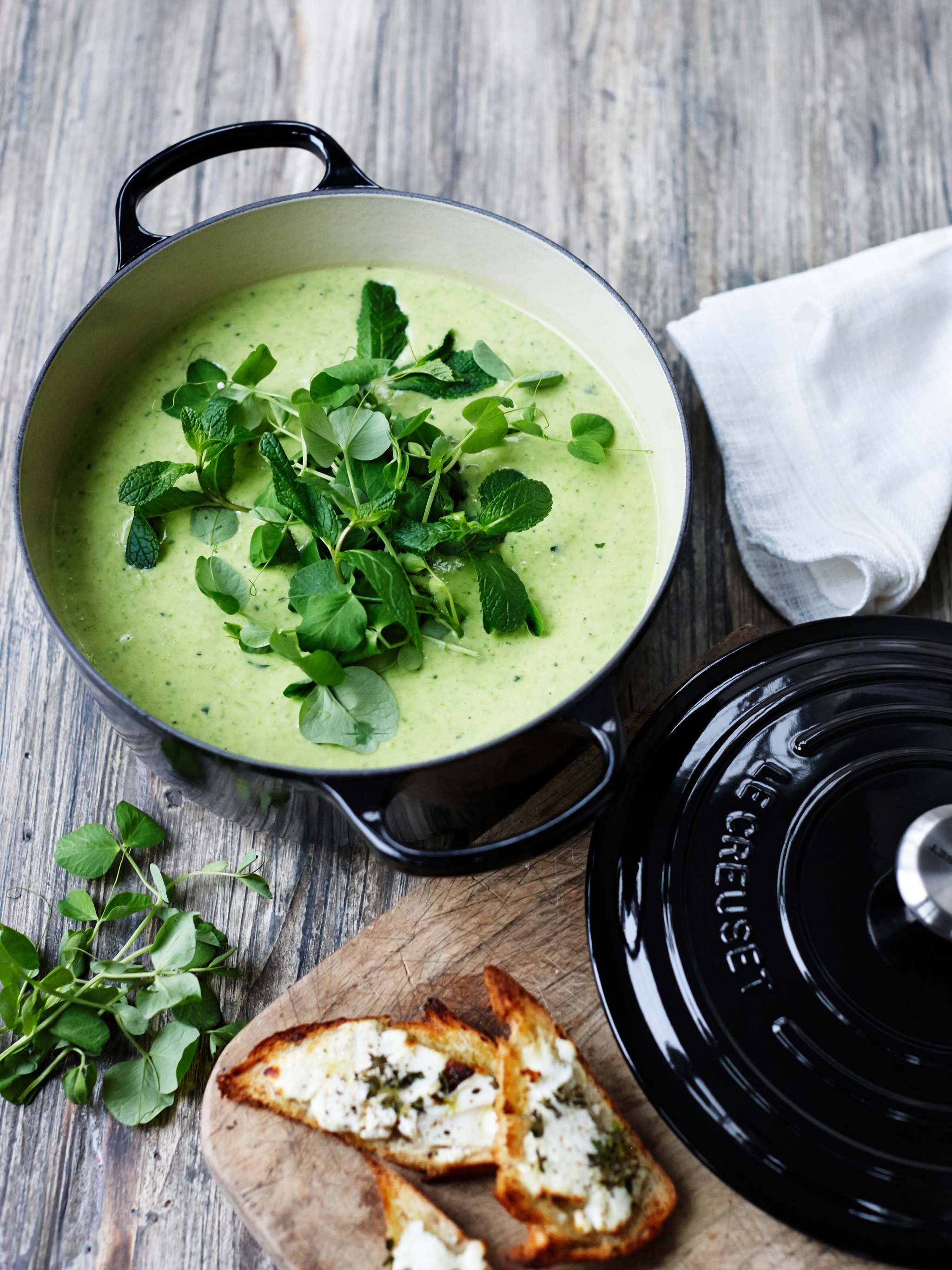 Le creuset svart gryte med grønn suppe i på spisebord