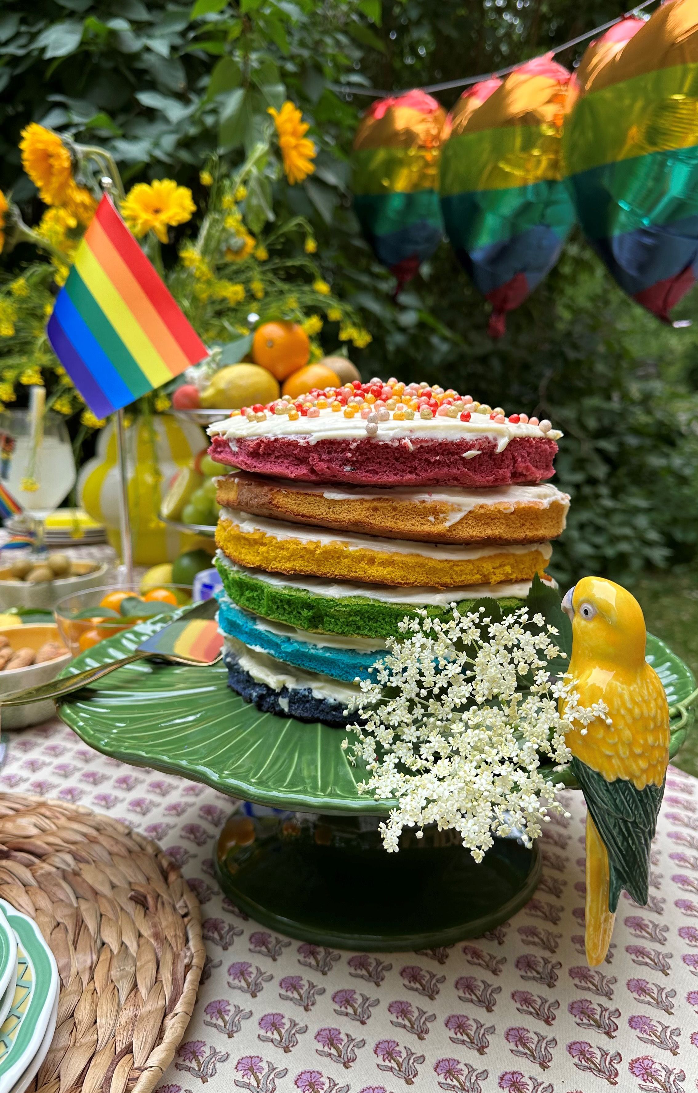 a rainbow cake with a rainbow flag in the background