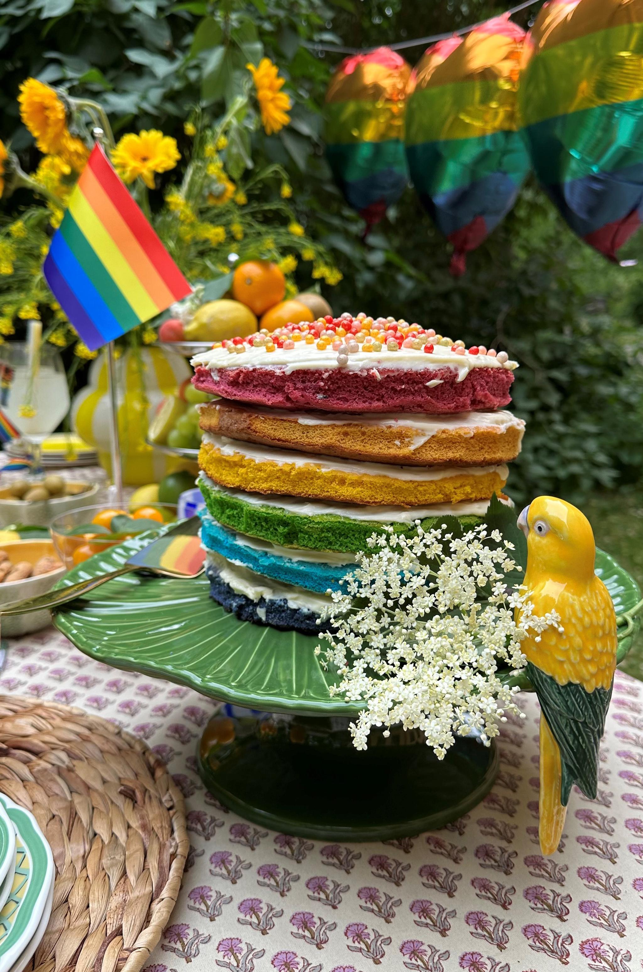 a rainbow cake with a rainbow flag in the background