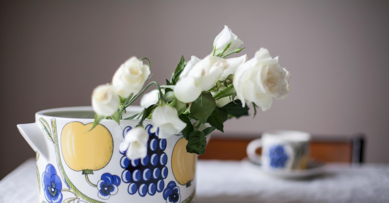 Arabian kaadin kiettiön pöydällä jota koristaa siniset kukat keltaiset omenat ja siniset marjat