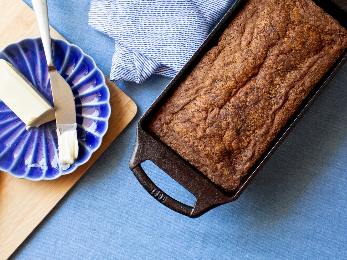 Brødform med nybakt brød på en blå kjøkkenbenk