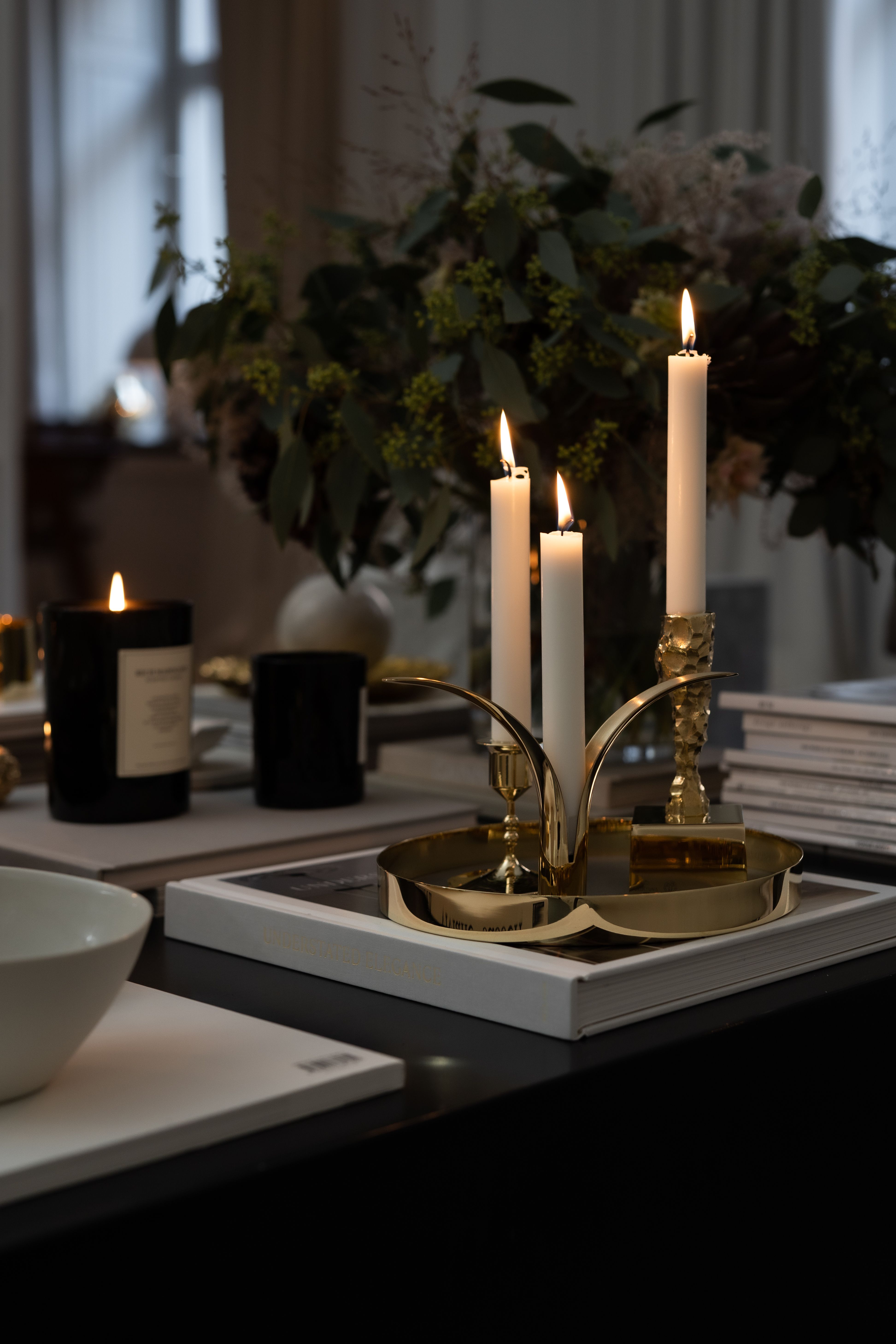 Tända ljus i mässingljusstakar från Skultuna står på ett marmorbord