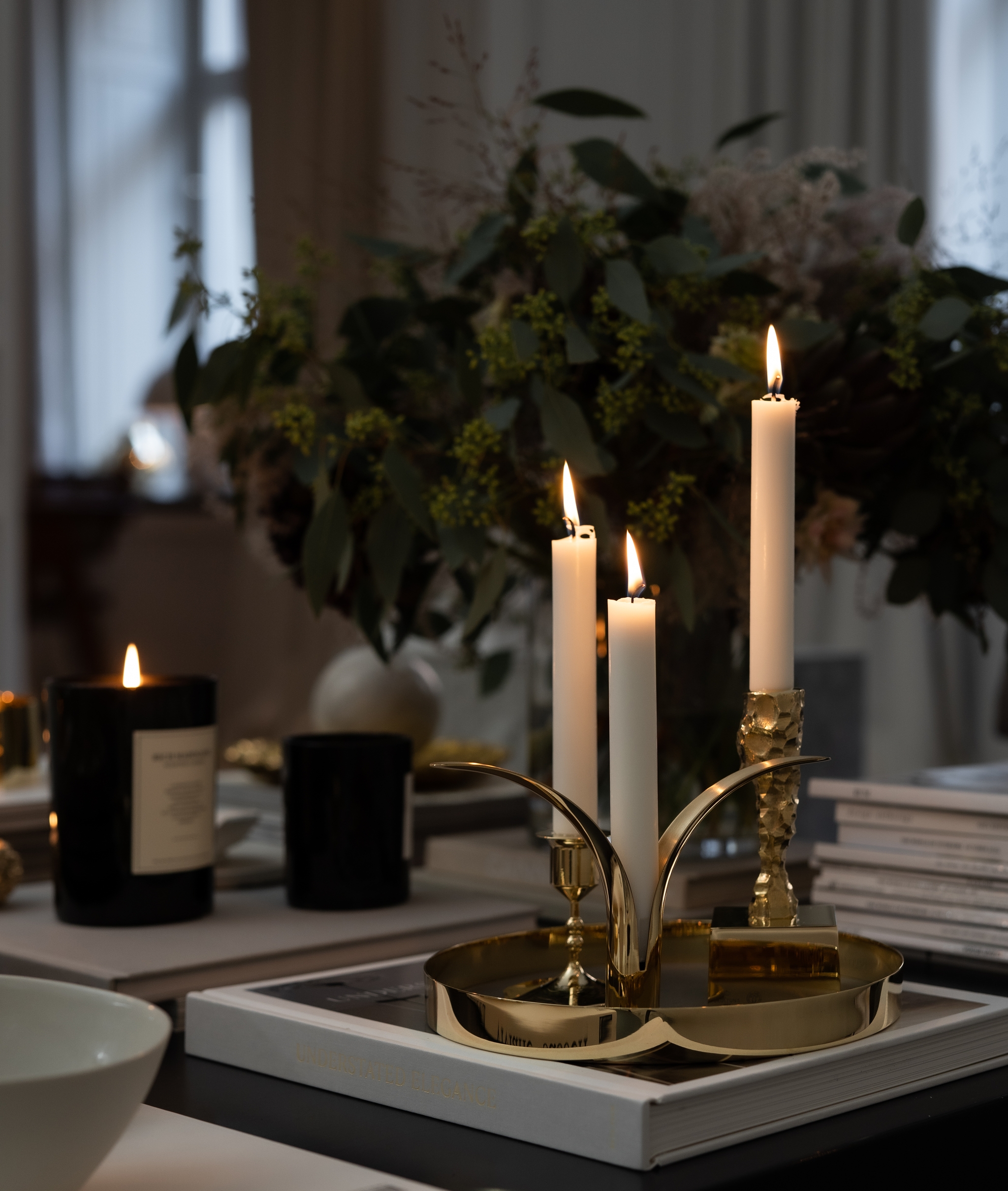 Tända ljus i mässingljusstakar från Skultuna står på ett marmorbord