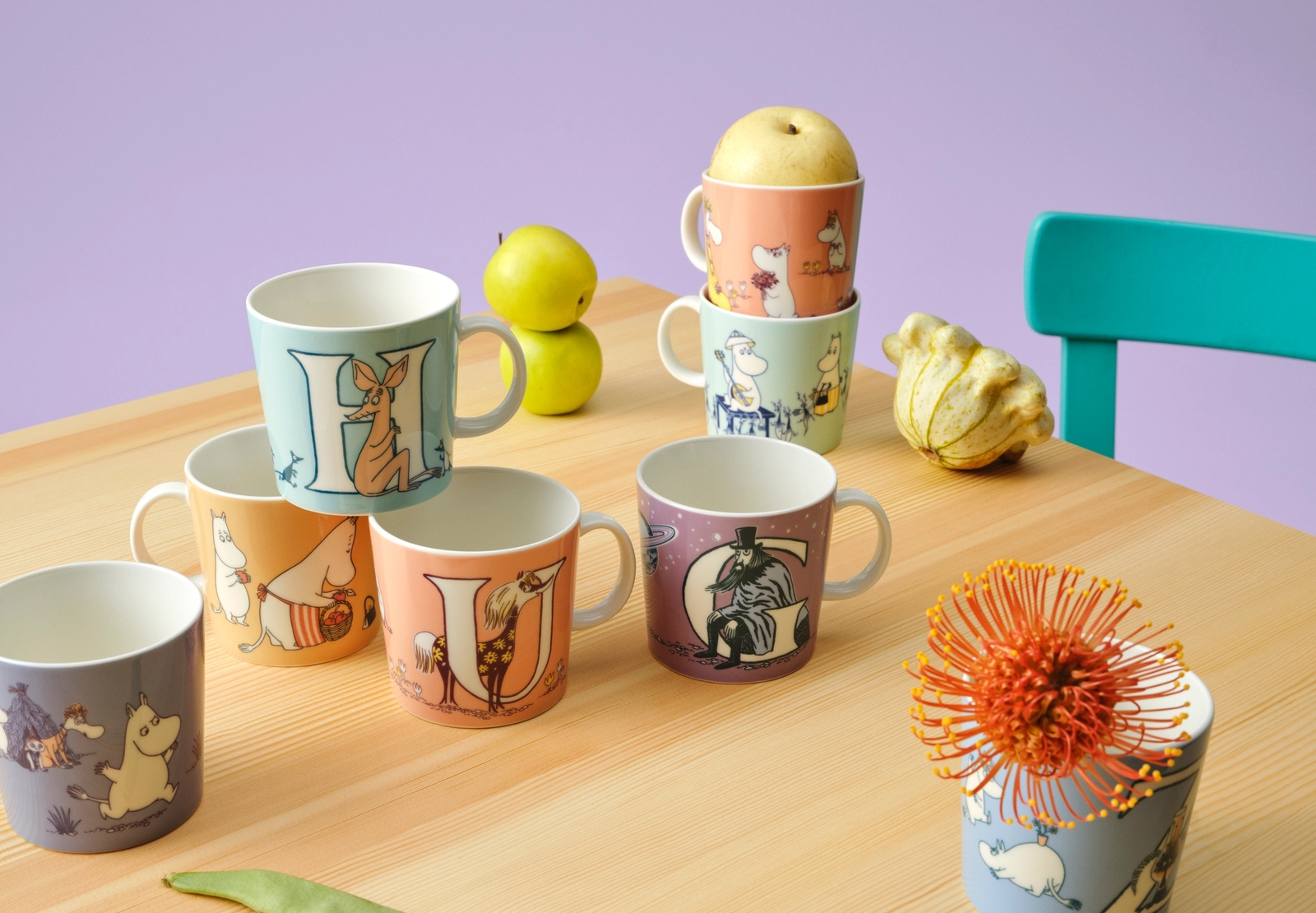 Moomin arabia muggar på en hylla i ett lila rum