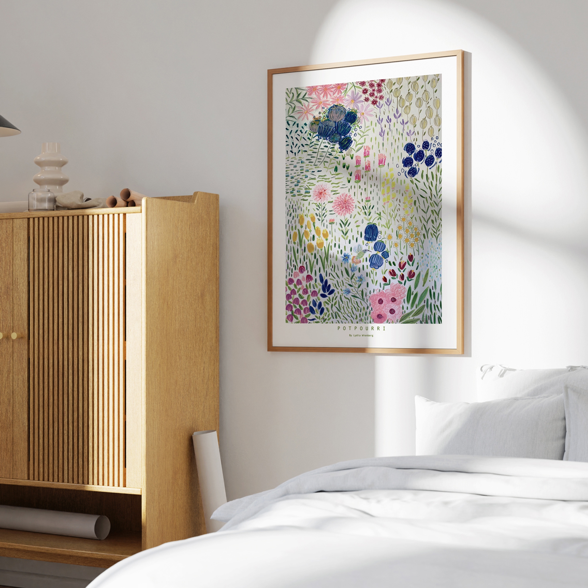 Sovrum med en vit bäddad säng, bredvid en trä garderob och på väggen hänger en färgglad tavla med blommotiv