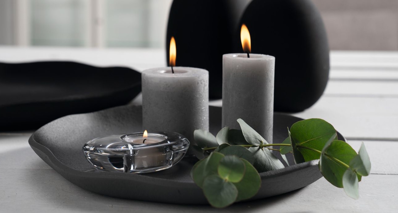 Lysfat i grått med grå kubbelys på og en hjerteformet lyslykt i glass