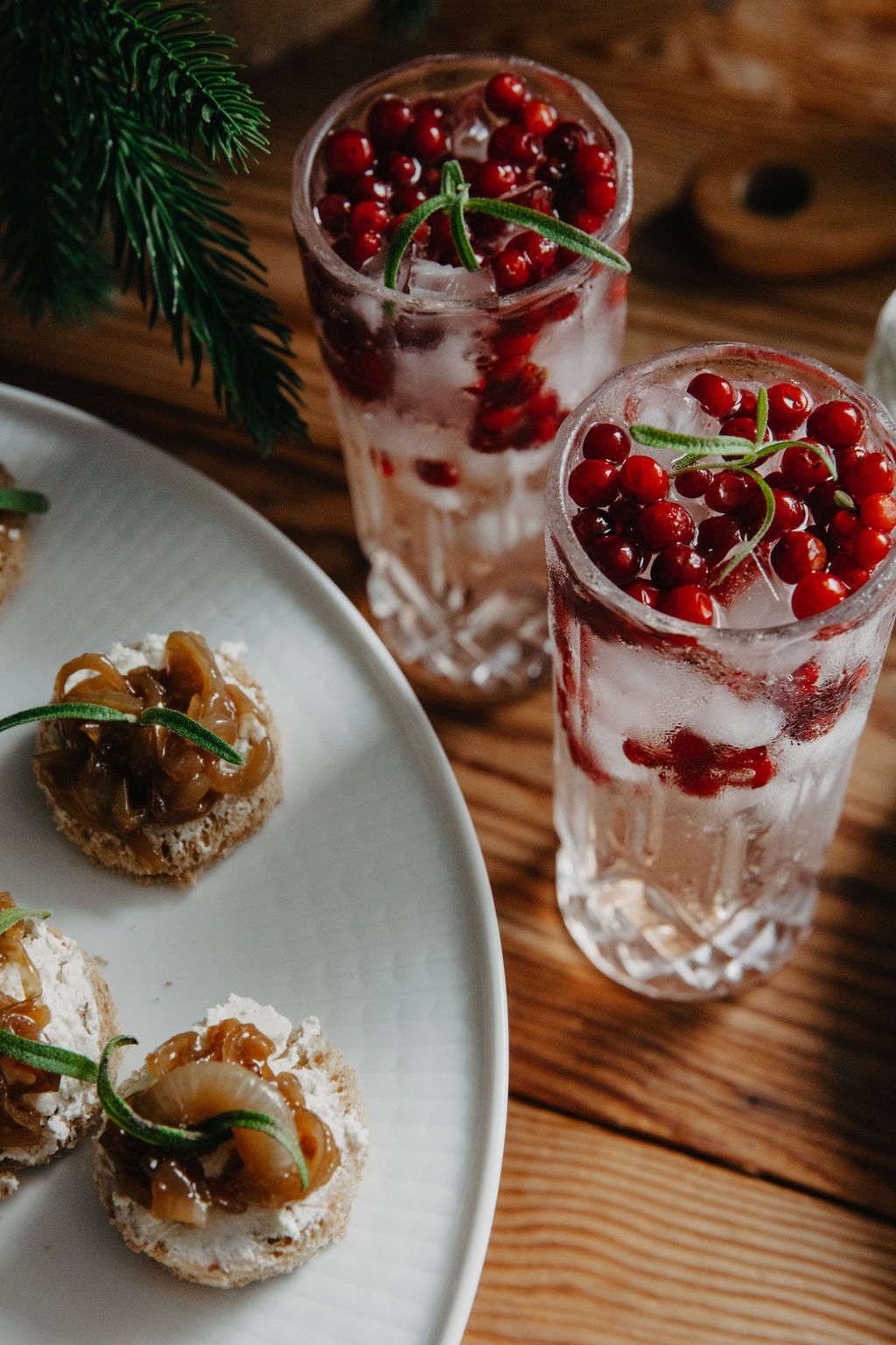 Puolukka gin & tonic korkeassa lasissa ja alkupalat lautasella