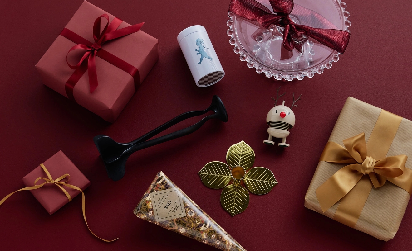 An assortment of festive gifts and decorative objects on a red background.