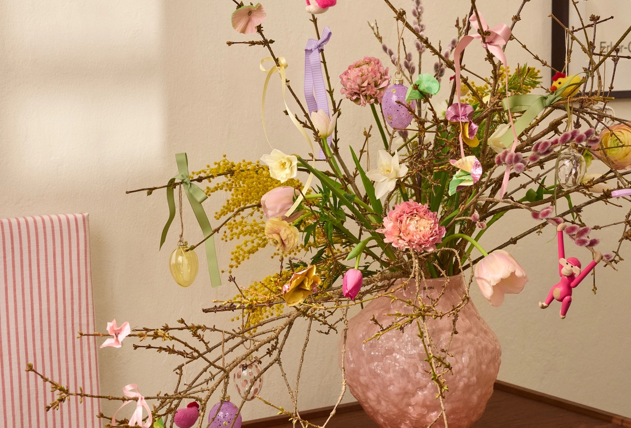 a pink vase filled with flowers sits on a table