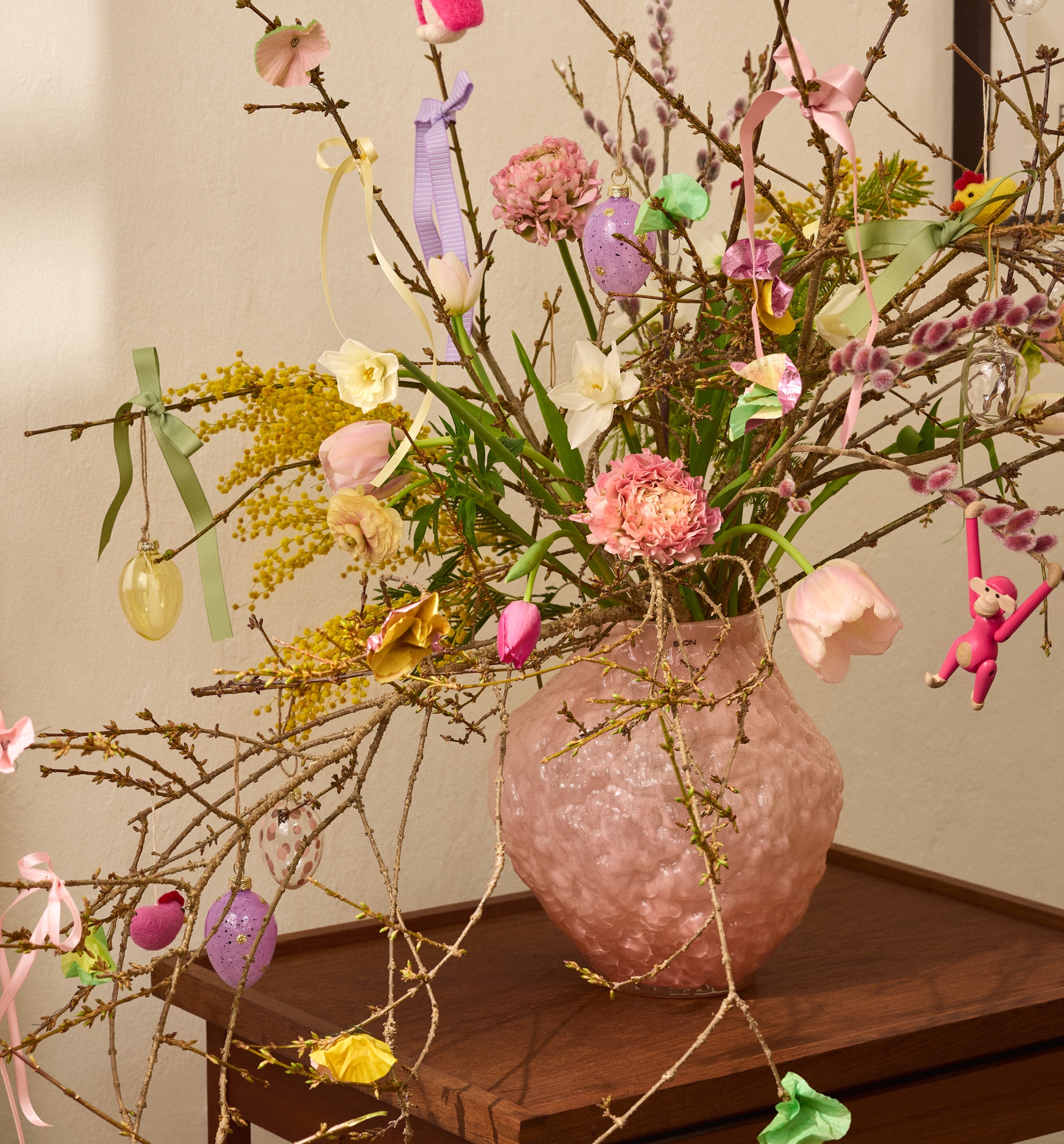 Påskris med dekorationer i en rosa vas