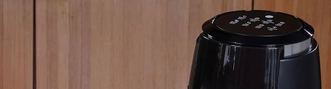 Musta wilfa airfryer ja makea piirakka mustikoiden kera vaaleansinisellä lautasella