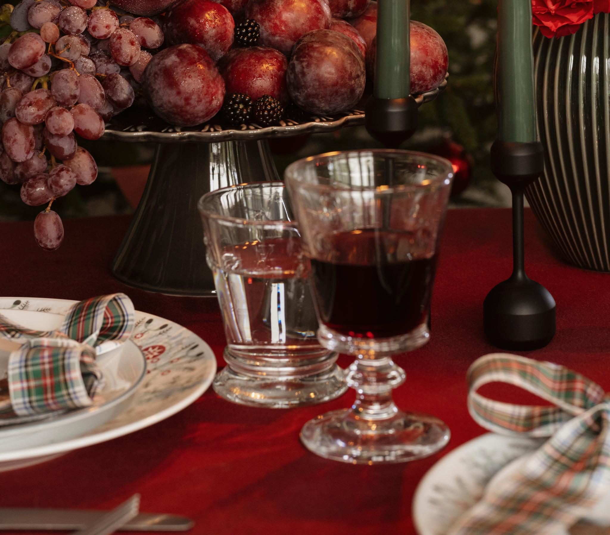 a table set for a christmas dinner with fruit and candles