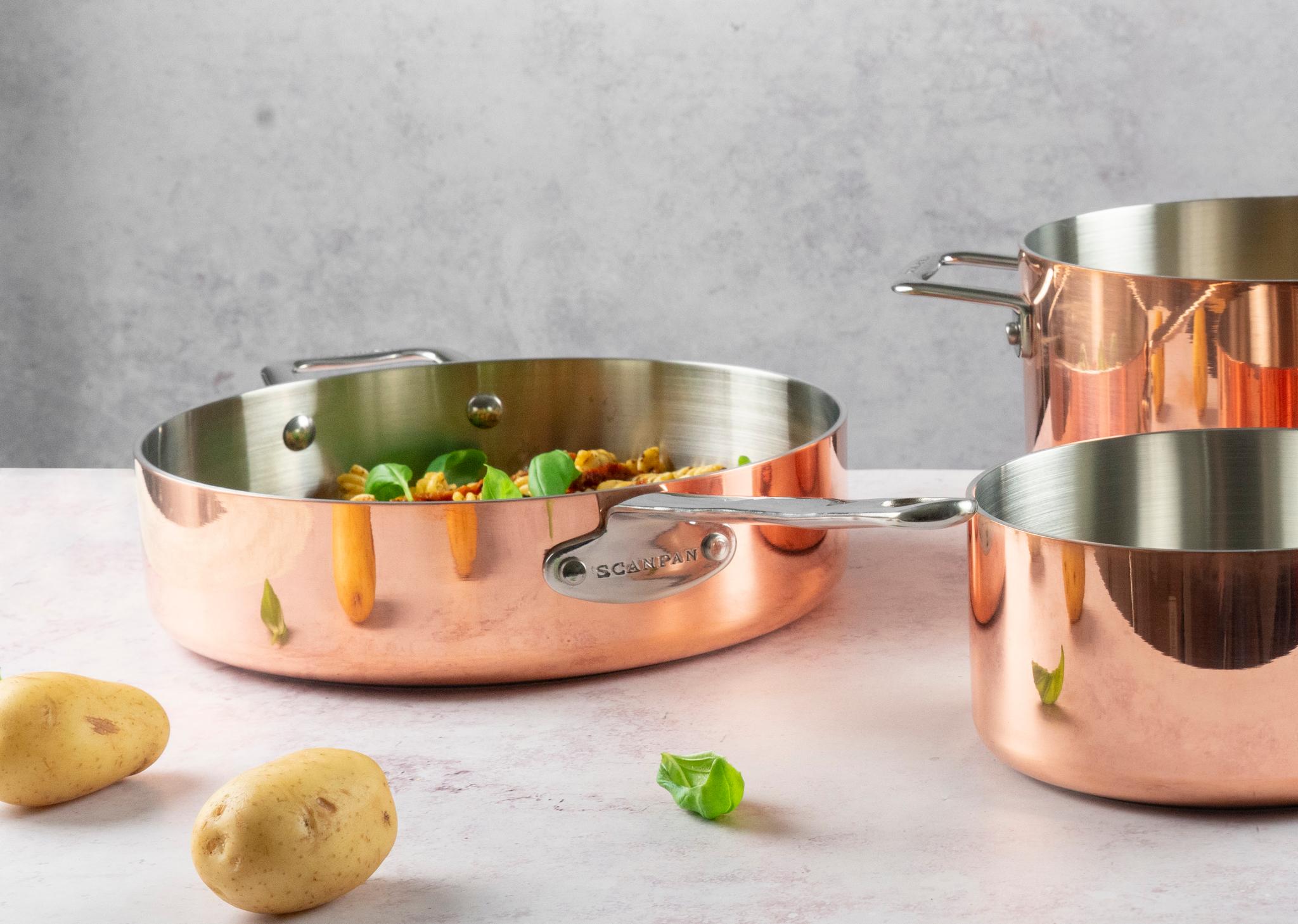 kopparstekpannor på marmorskiva och potatisar