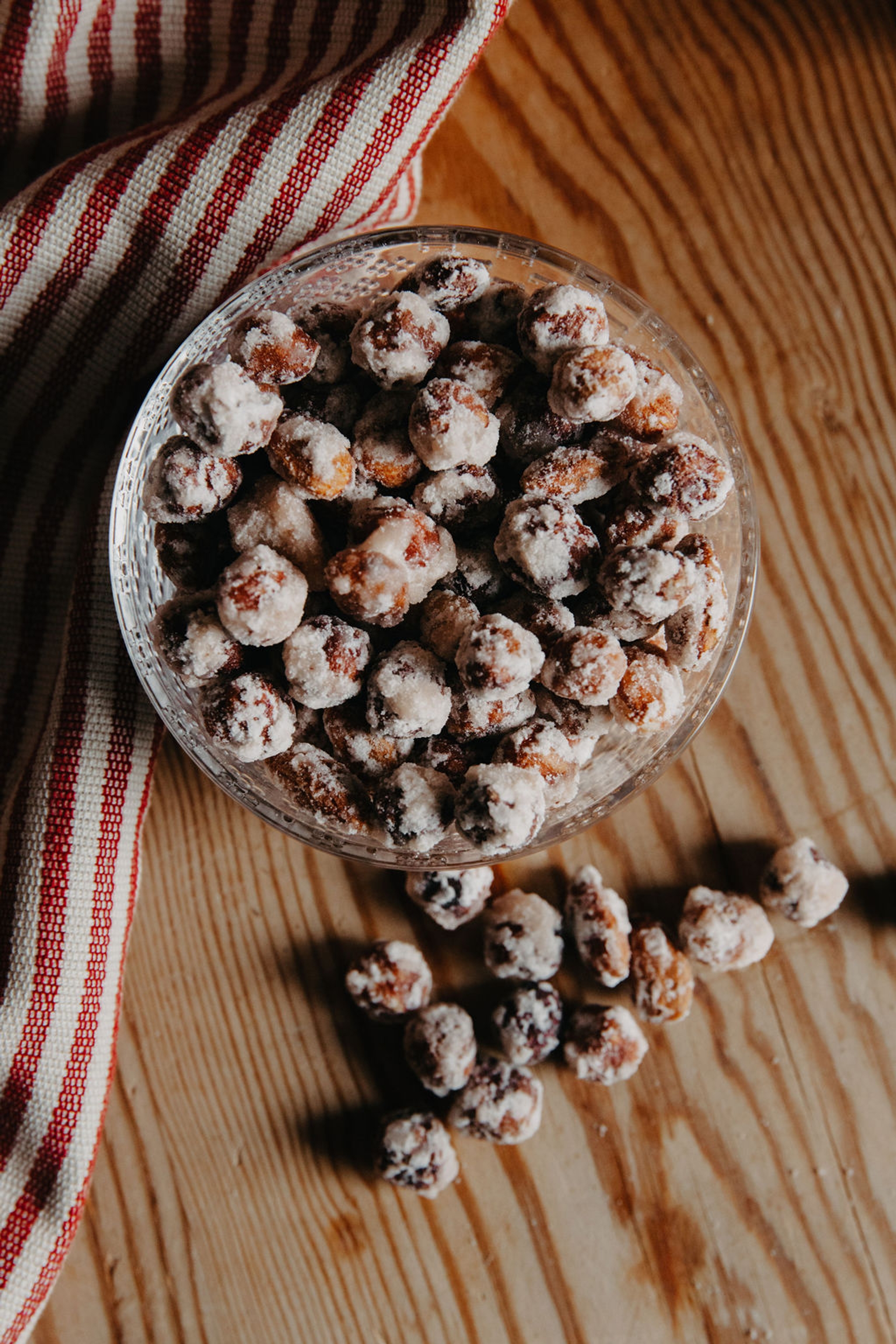 Paahdetut mantelit & hasselpähkinät kulhossa puisella pöydällä 