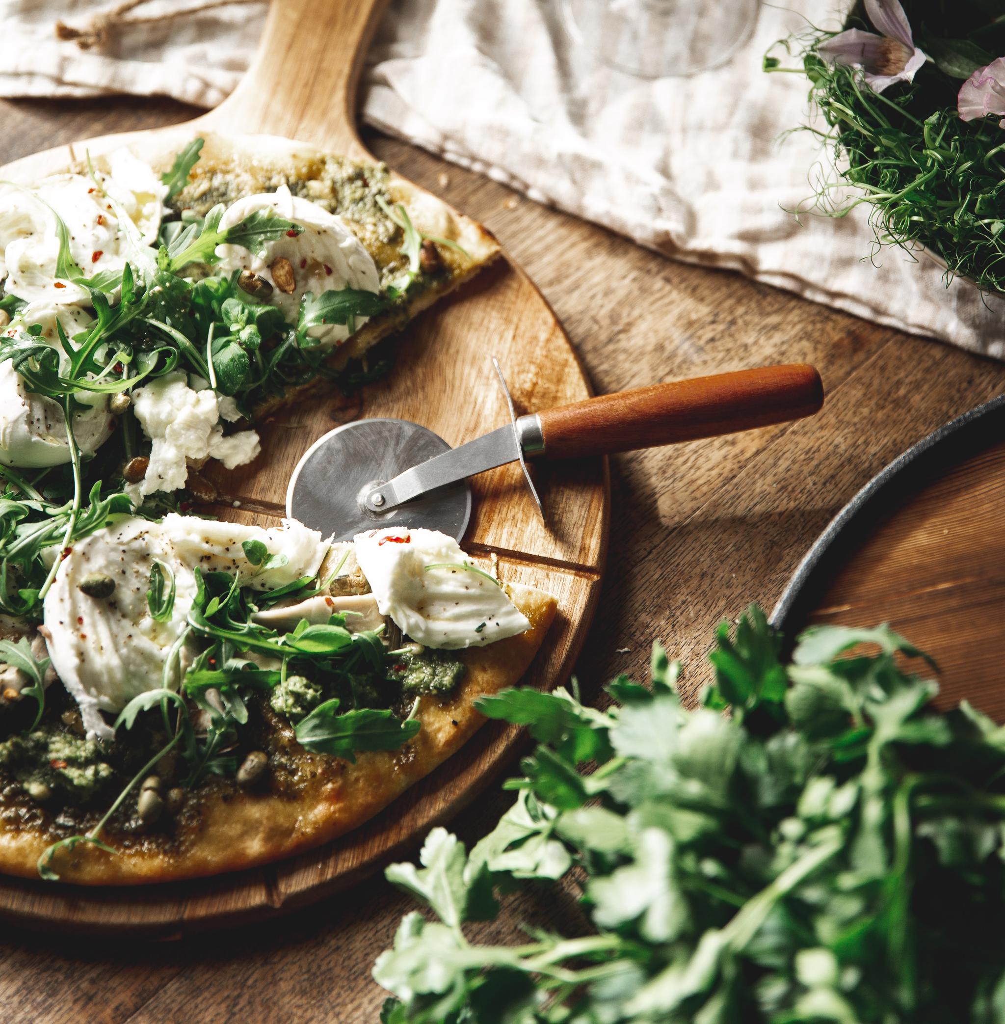 Pizza med ruccola, pesto och pinjenötter