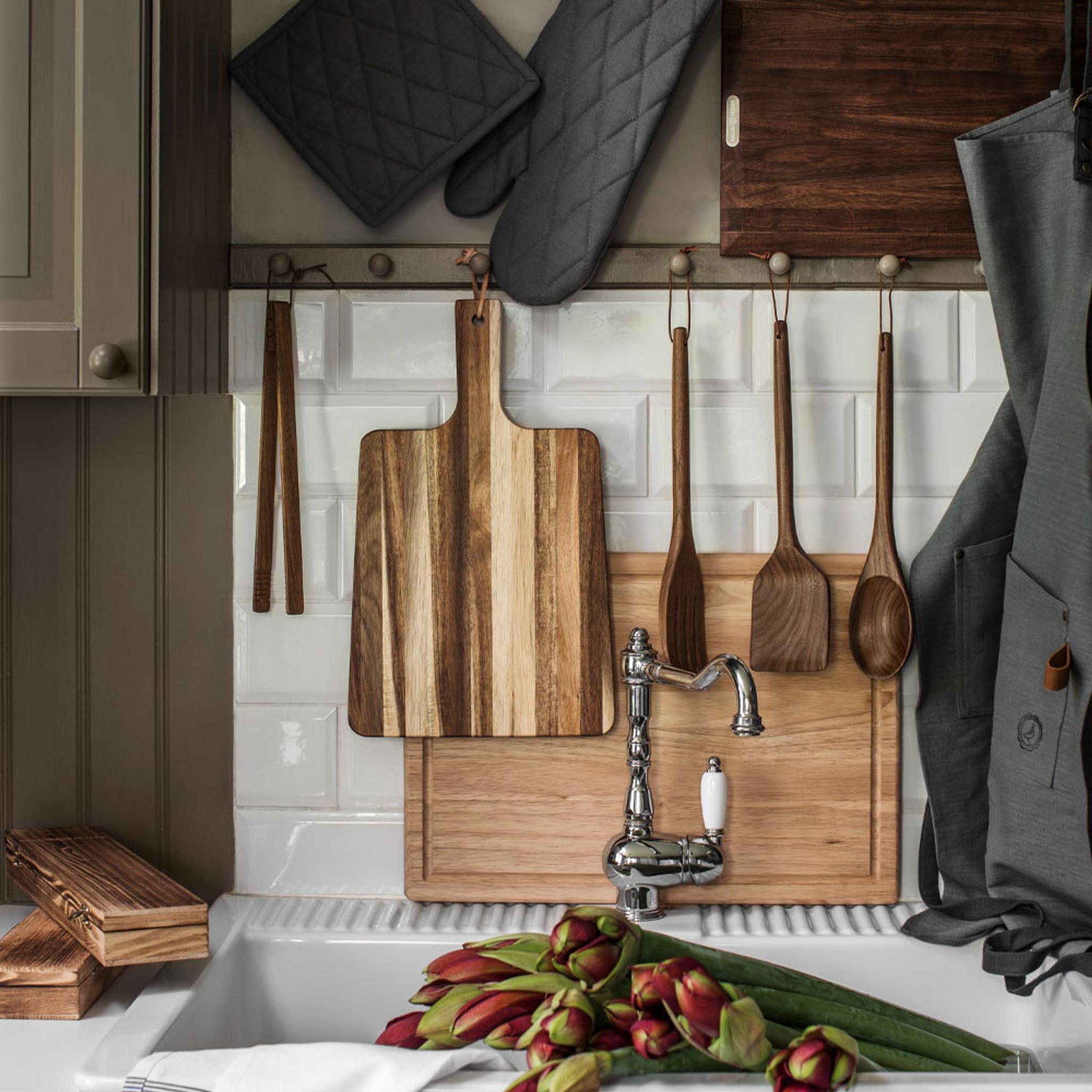a kitchen with wooden cutting boards and utensils hanging on the wall