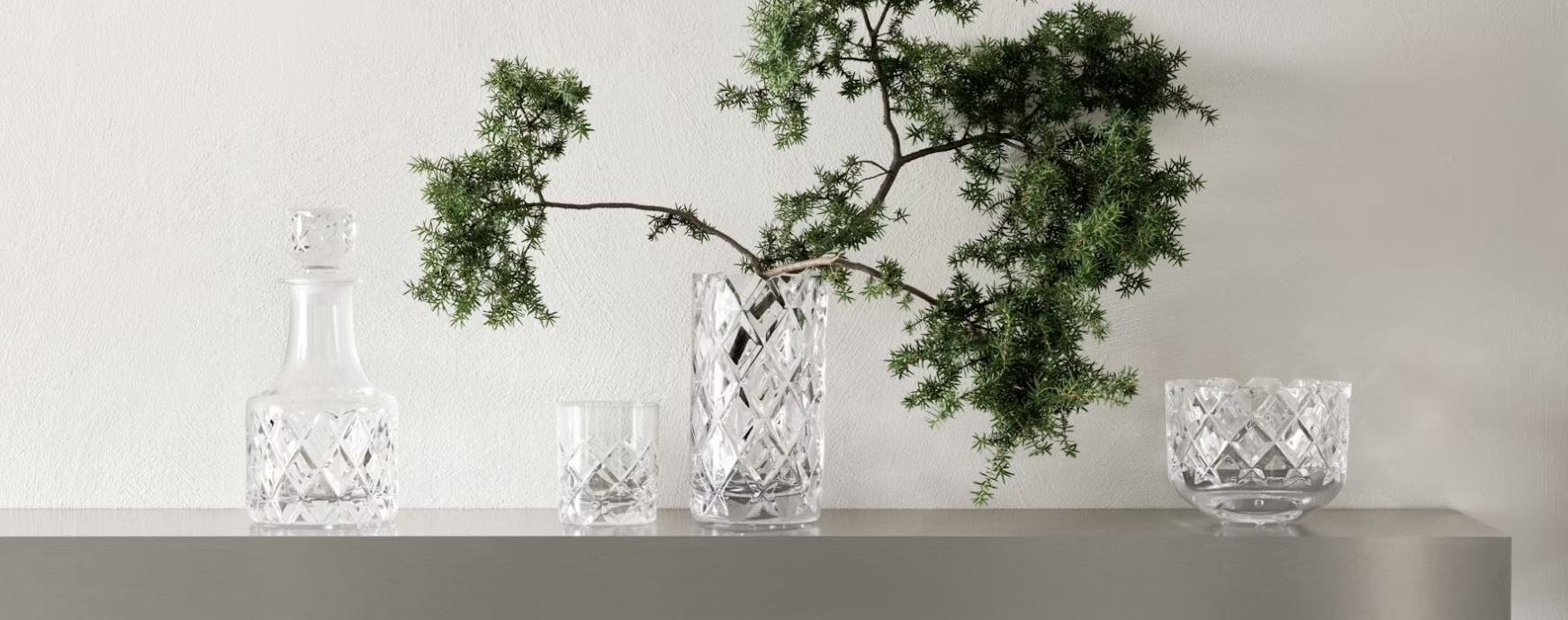 Sofiero karaffel, vase, skål og glass fra orrefors med en grønn gren i vasen