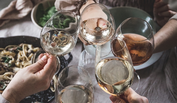 Vitvinsglas med vitt vin i skålar över bord