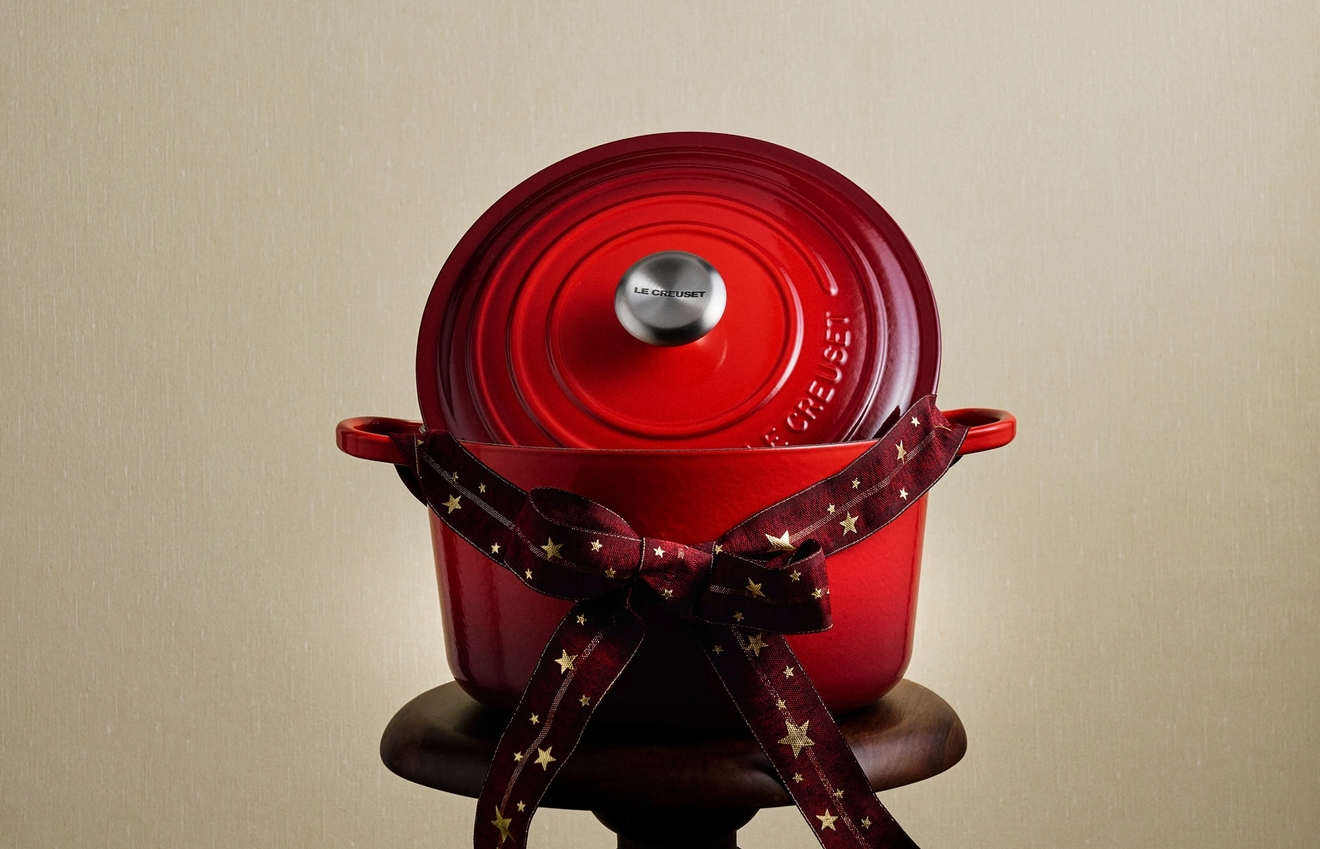 En röd Le Creuset-gryta med en rosett på en pidestal