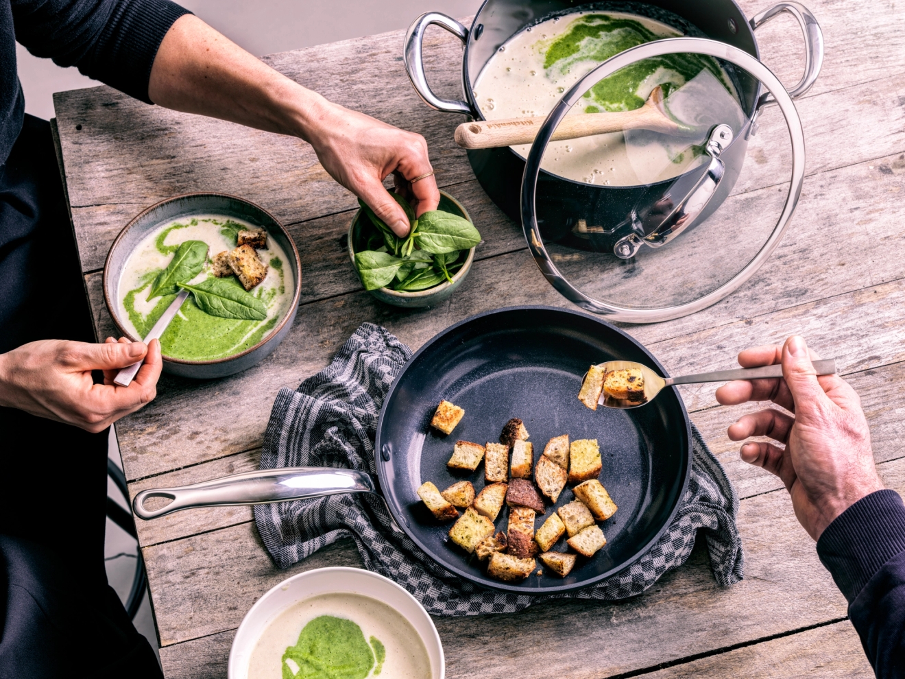 Pinnoitettu paistinpannu ruokapöydällä 