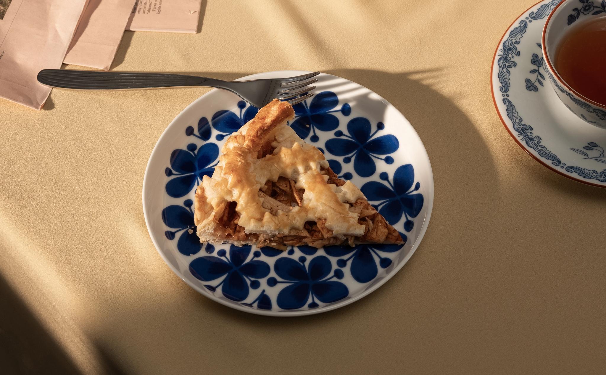 En blåvit assiett med en bit äppelpaj på