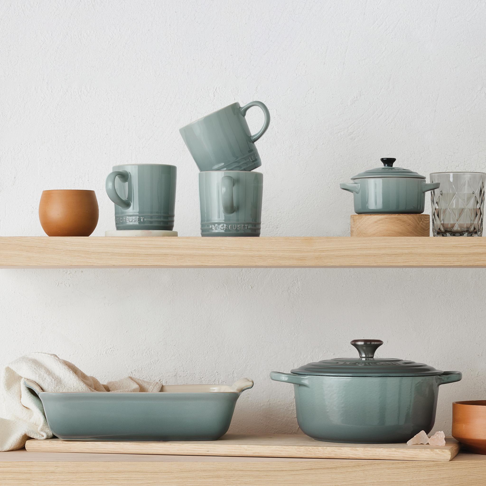 Le Creuset kollektionen i färgen Sea Salt på en hylla - gryta, ugnsform och koppar