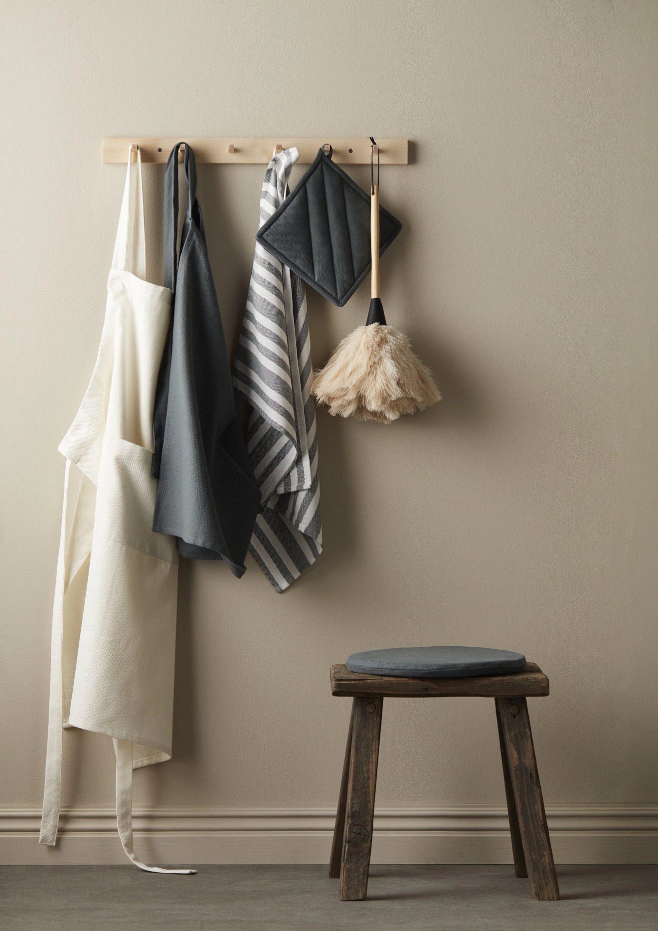 Svanefors förkläden vita och blå hängandes på krokar mot beige bakgrund 