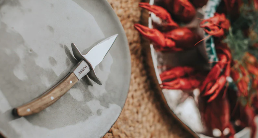 Skalldyrsbestikk, skalldyrskniv med kreps i bakgrunnen