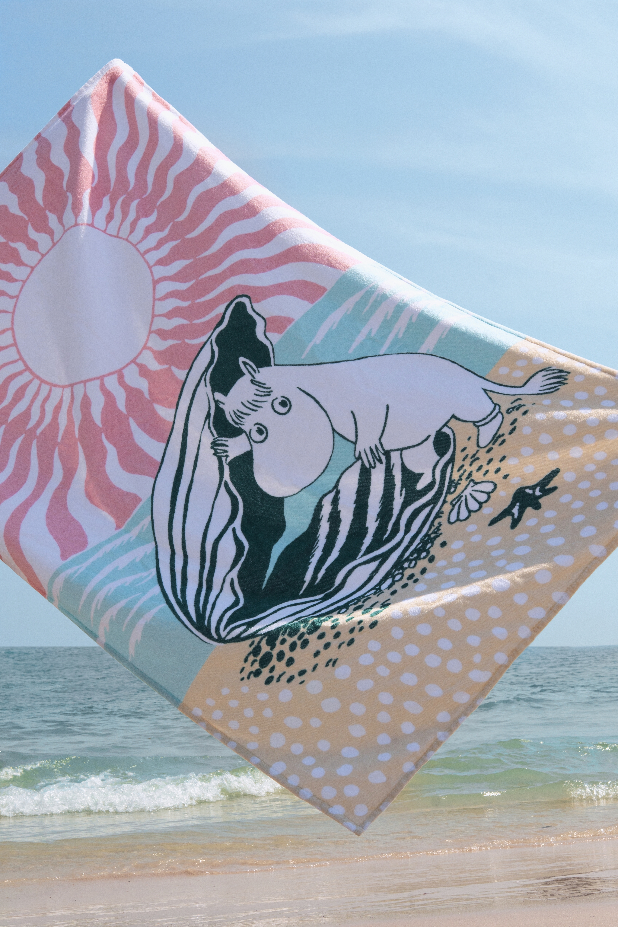 Strandhandduk från Mumin torkar i vinden på stranden