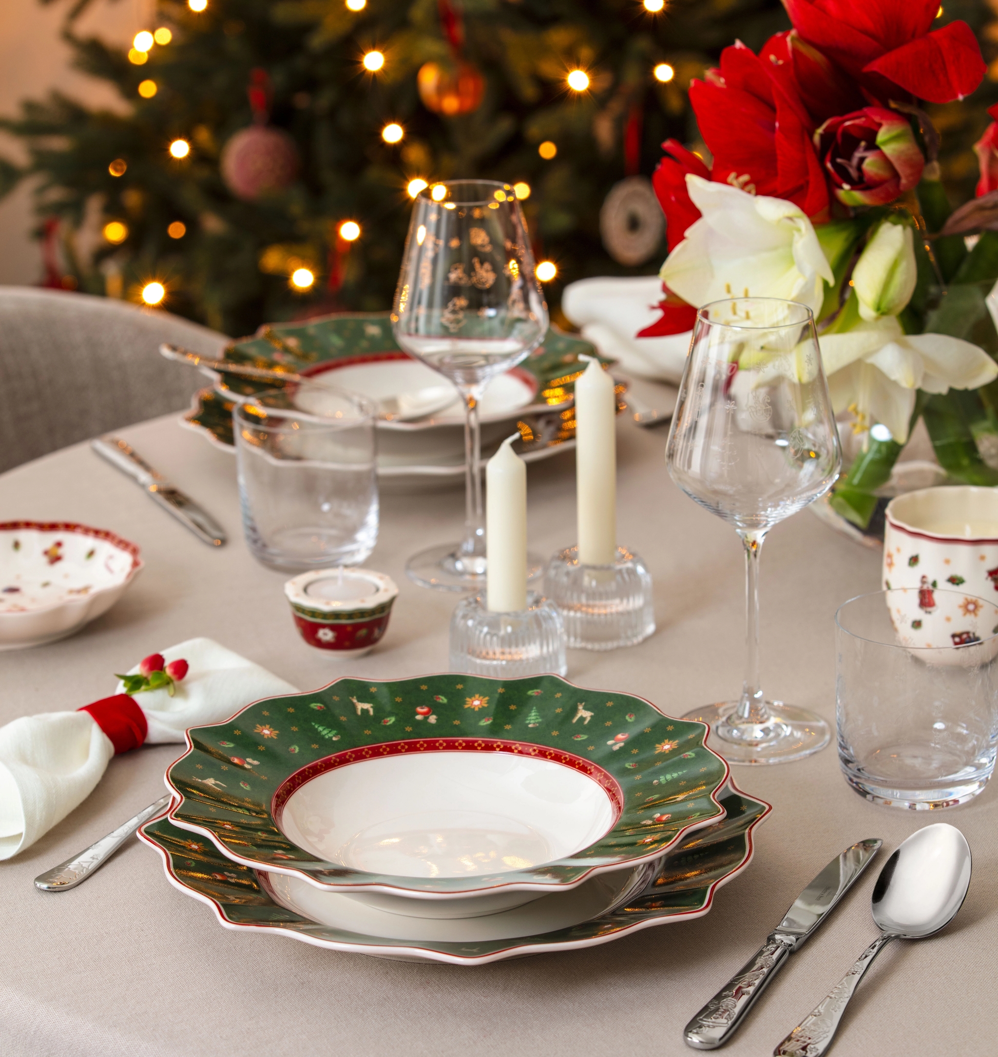 Ett dukat julbord med en julgran i bakgrunden