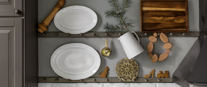 Fat hvite stående mot grå vegg blant andre kjøkkenting som dekorerer veggene