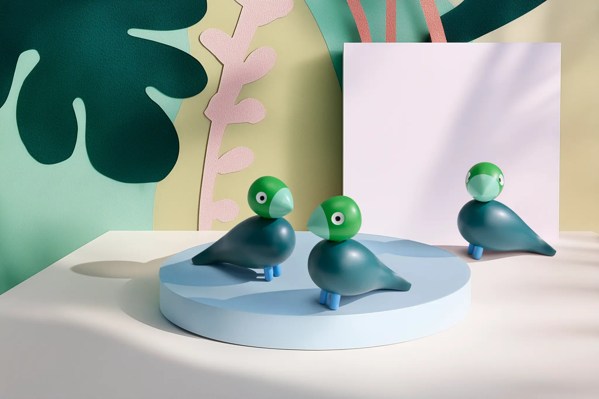 Gröna träfåglar från Kay Bojesen mot en pastellfärgad bakgrund