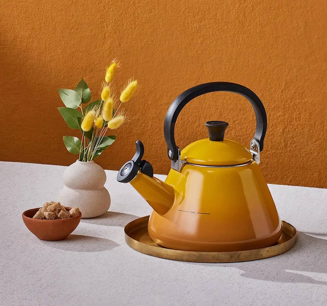 Keltainen Le Creuset vesipannu tarjottimella