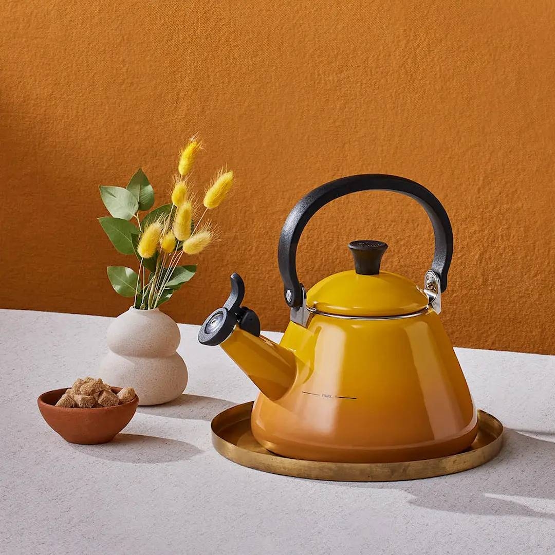 Keltainen Le Creuset vesipannu tarjottimella