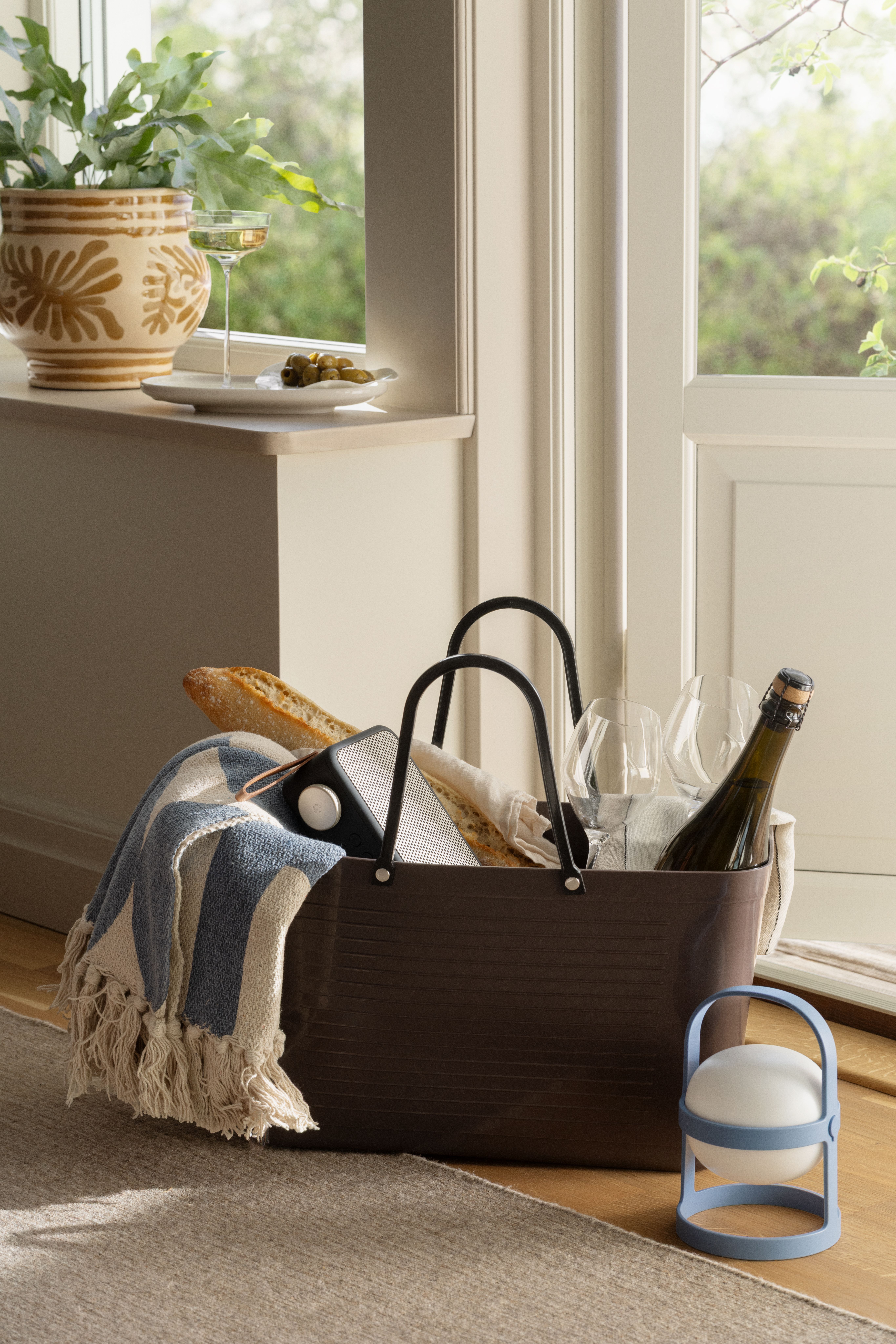 En brun plastväska från Hinza fylld med picknick-saker