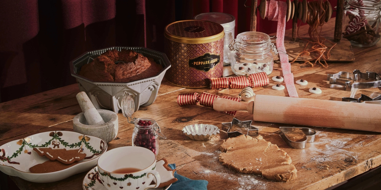 Julbakning med en kavel, pepparkakor och mintkyssar på ett bakbord