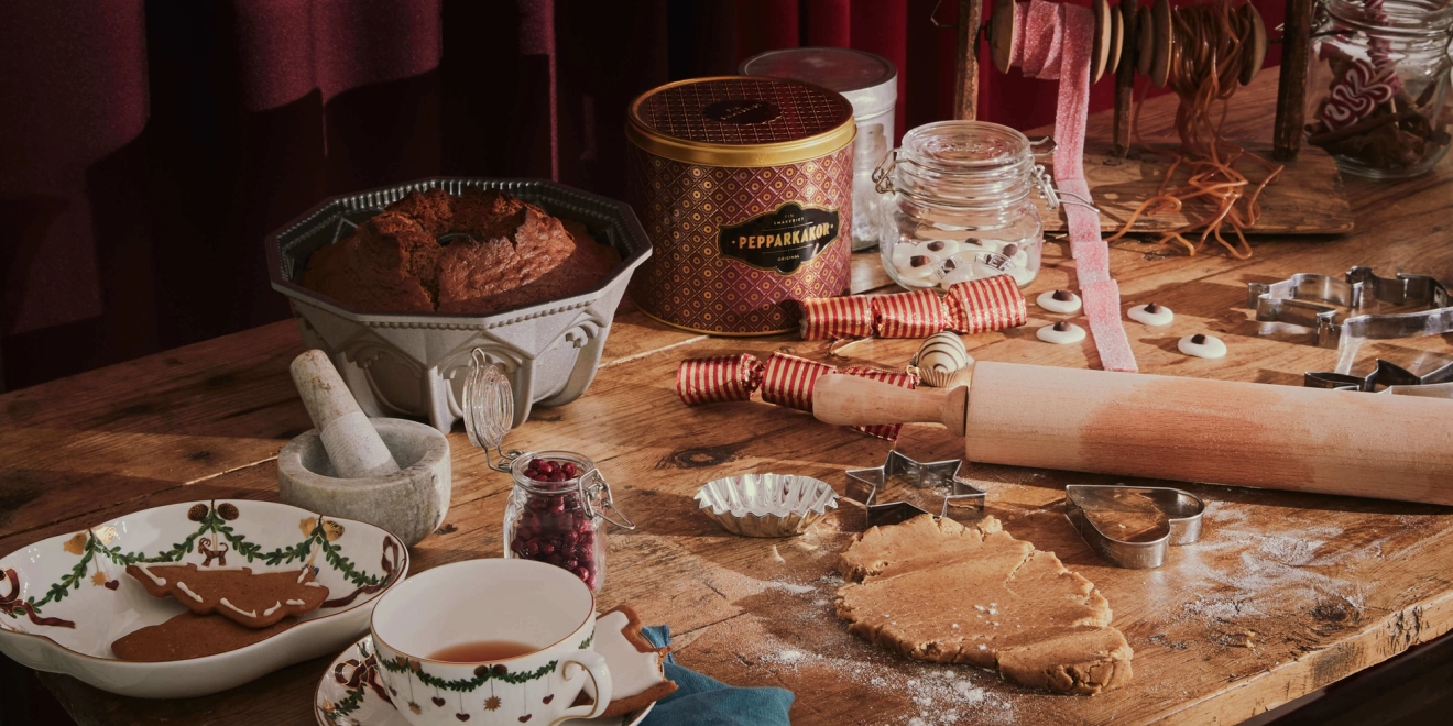 Julbakning med en kavel, pepparkakor och mintkyssar på ett bakbord