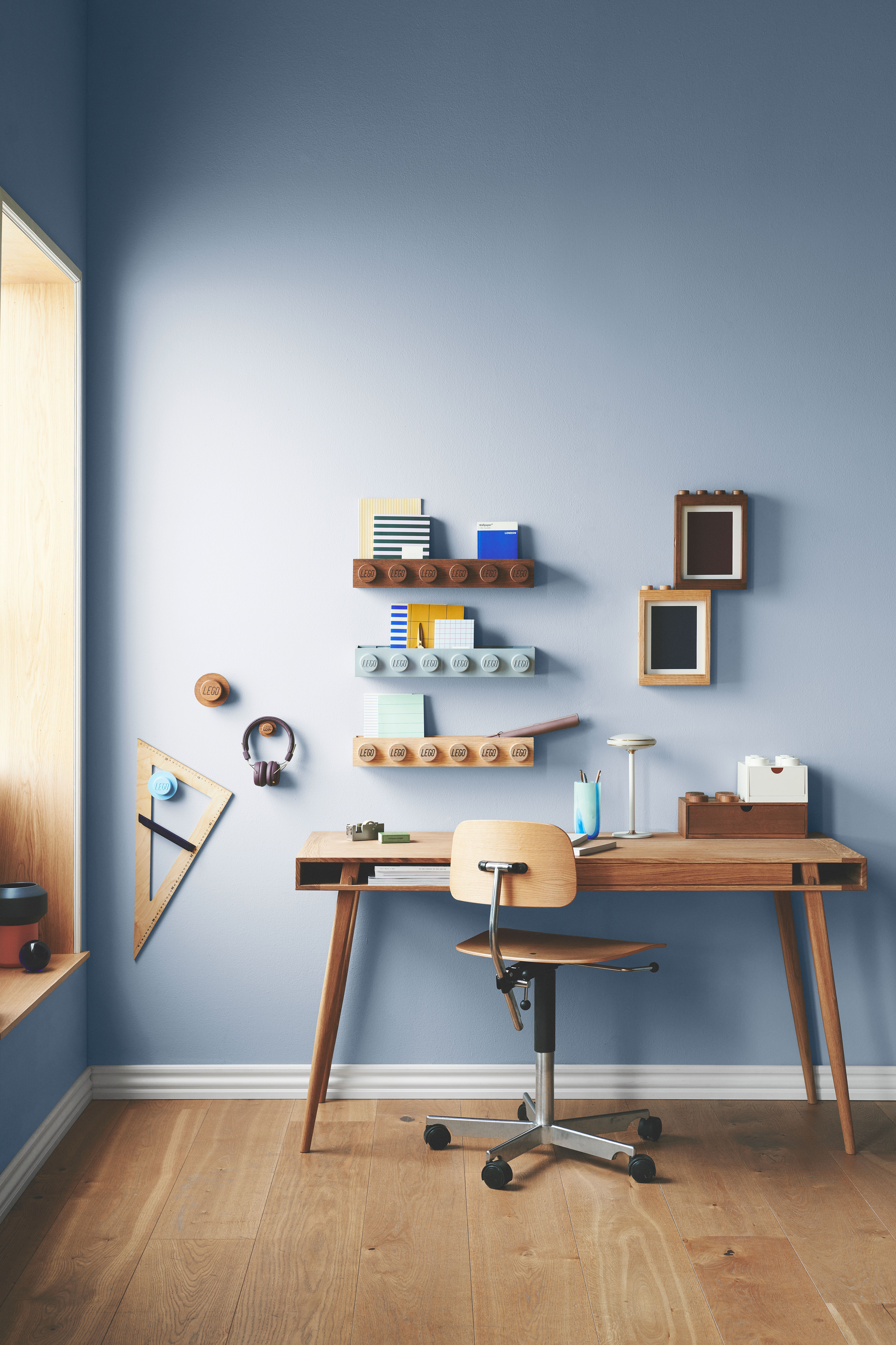 Barnrum med blåa väggar och ett skrivbord med rullstol i trä