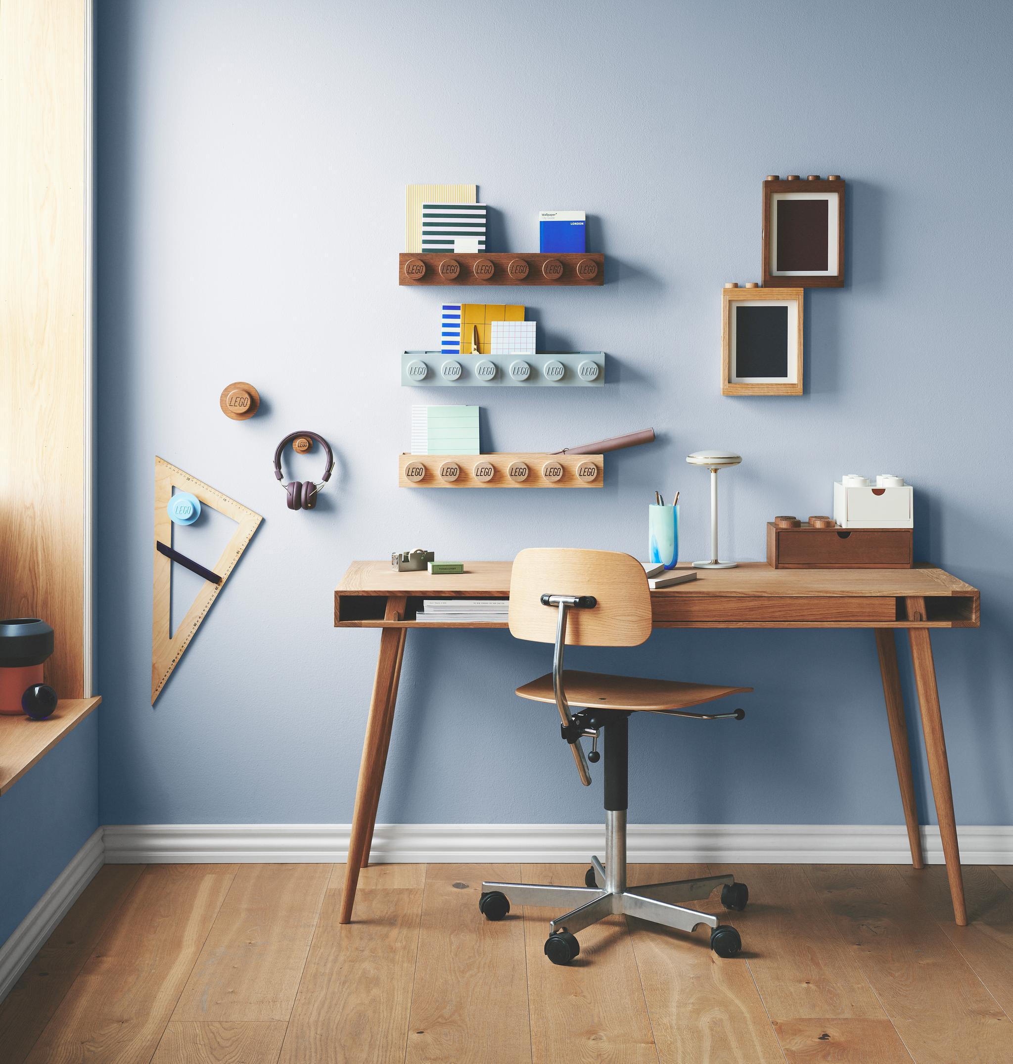 Barnrum med blåa väggar och ett skrivbord med rullstol i trä