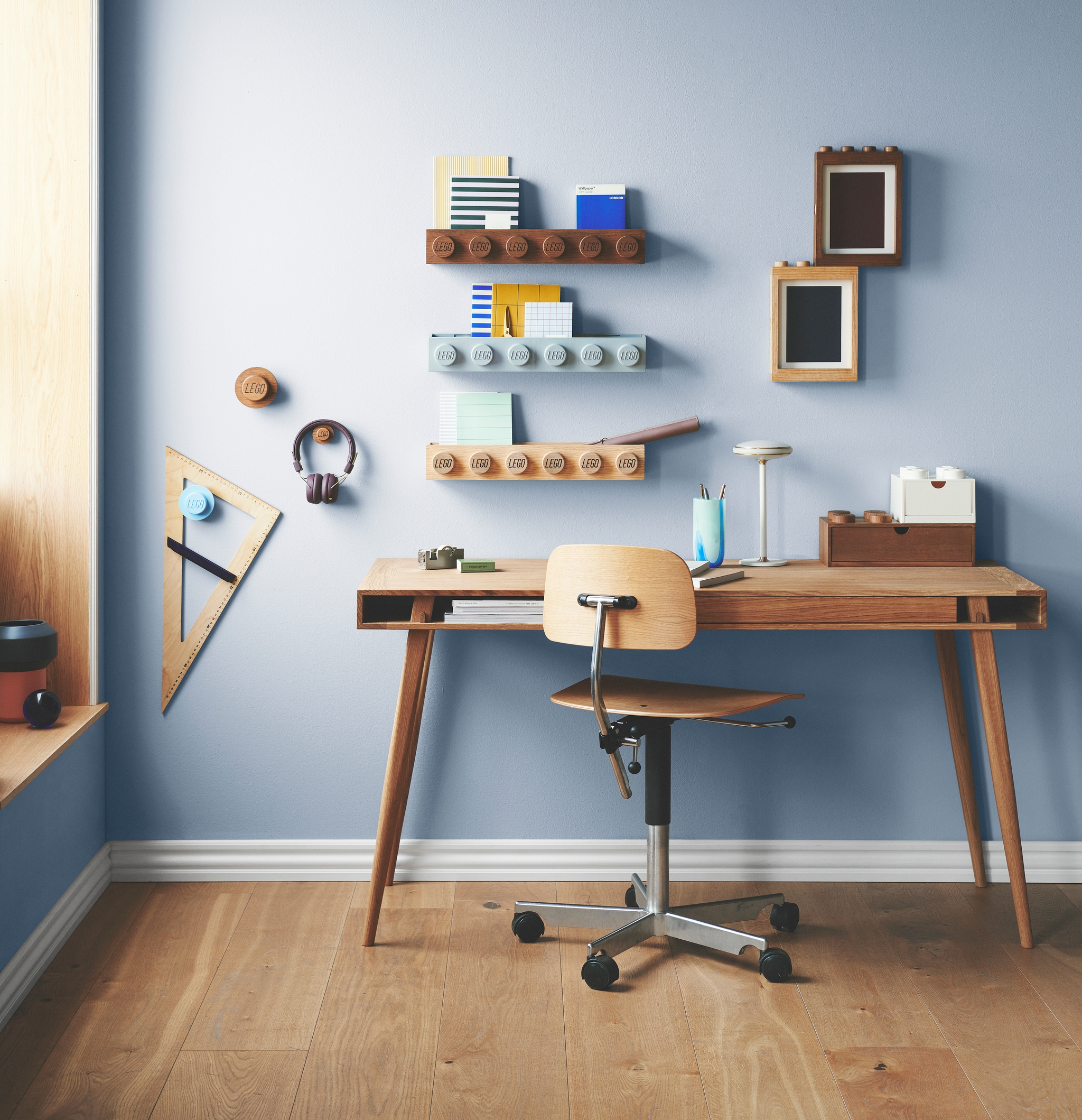 Barnrum med blåa väggar och ett skrivbord med rullstol i trä