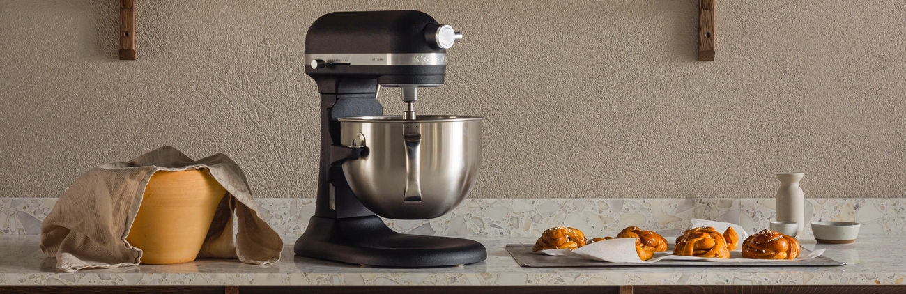 Svart kjøkkenmaskin på en kjøkkenbenk med baketilbehør