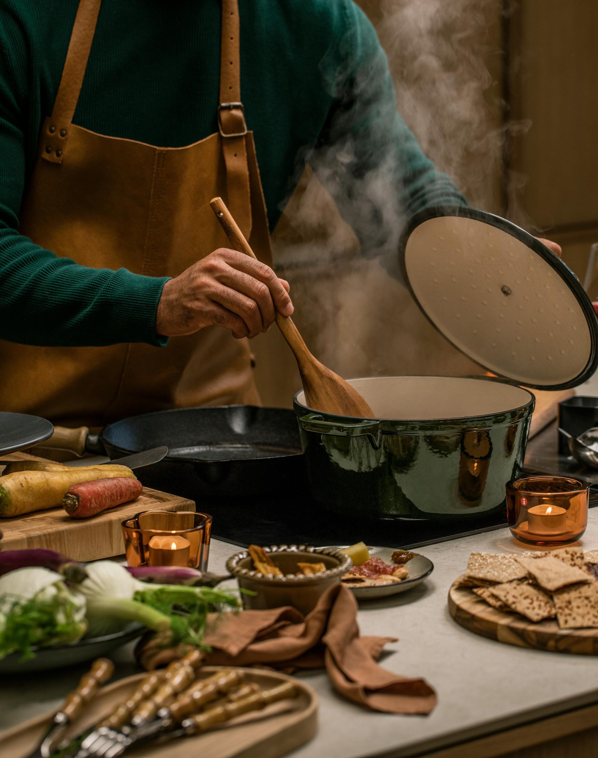 En person lagar mat i en gjutjärnsgryta