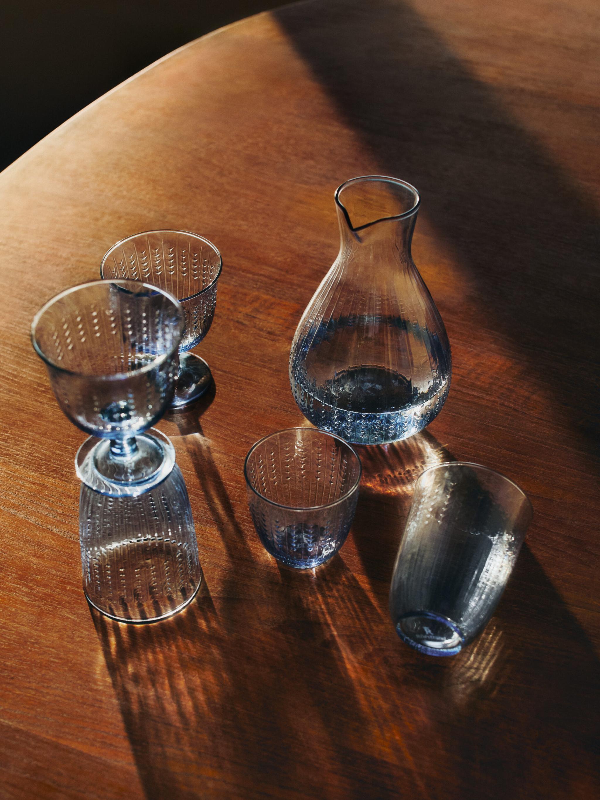 Glas från Swedish Grace i färgen blått på ett träbord