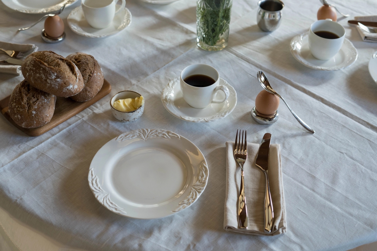 Smörgåsbestick på frukostbordet med ägg, kaffe och smörgåsar