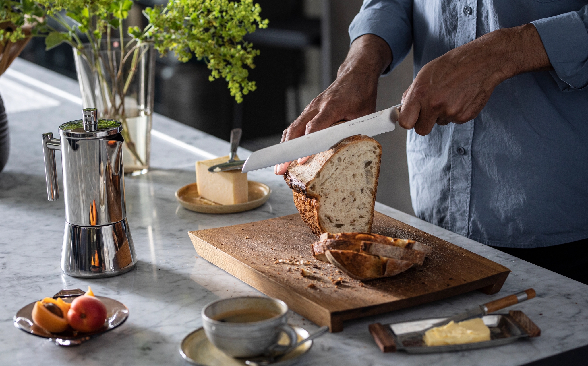 Leipäveitset puisella leikkuulaudalla sämpylöiden kera