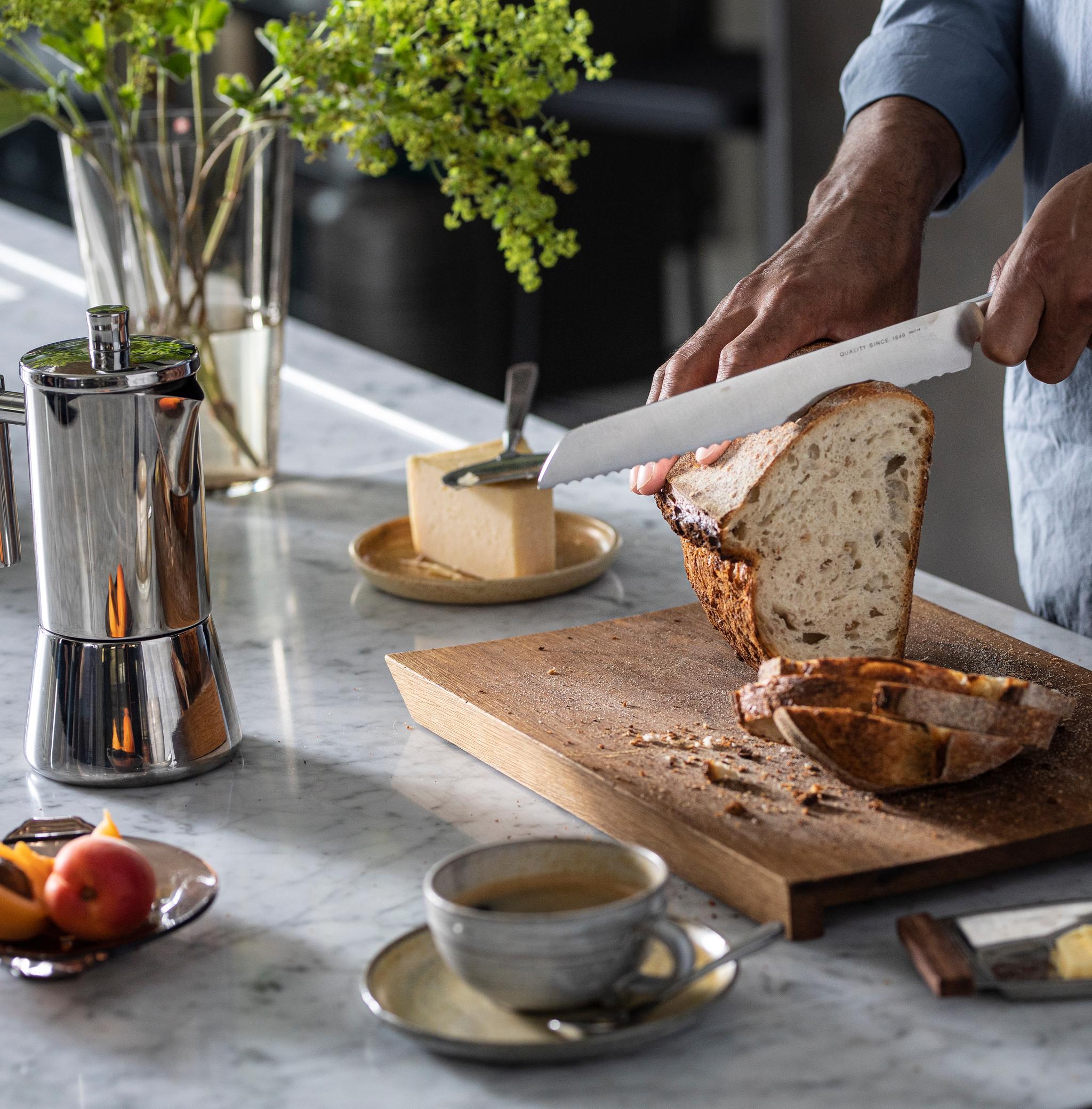 Leipäveitset puisella leikkuulaudalla sämpylöiden kera