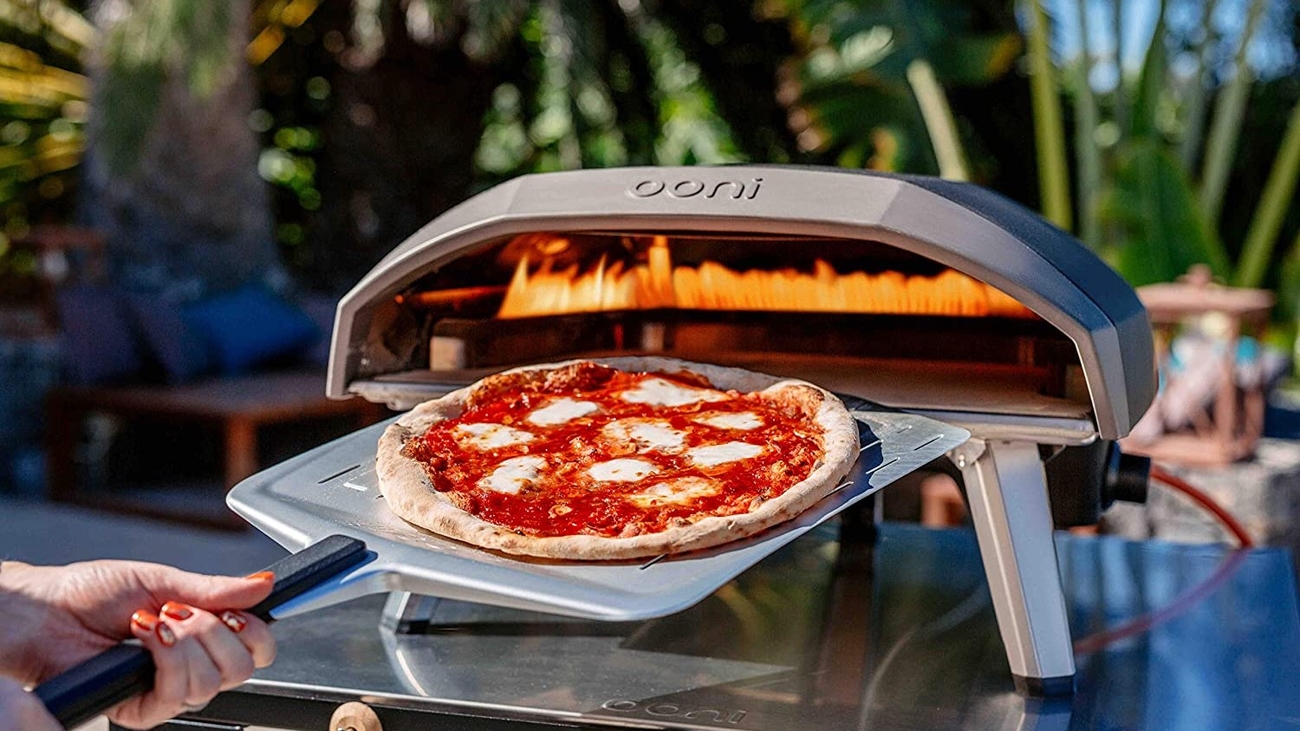Pizzaugn gasol från Ooni med en pizzaspade med en nygräddad pizza på